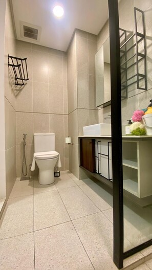 Un baño moderno con inodoro, ducha y zona de lavamanos.
