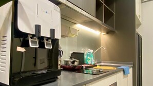 Una cocina moderna con cafetera integrada, estufa y microondas.