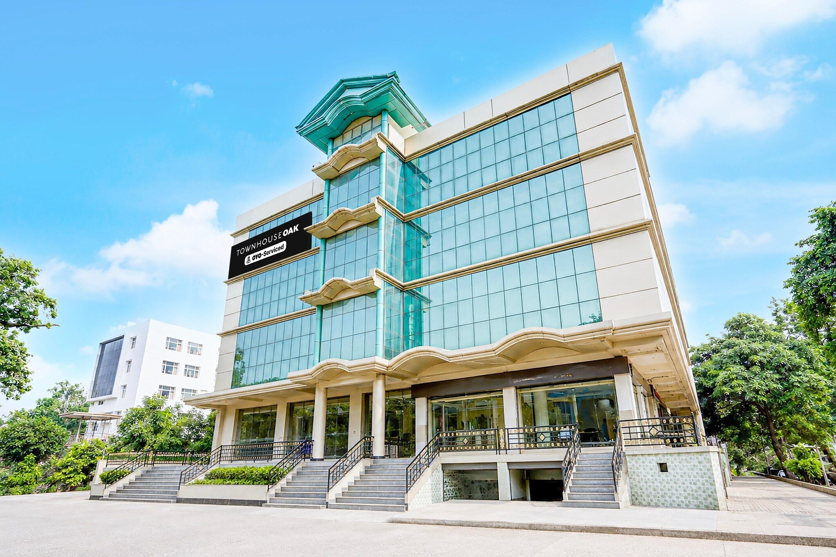 A multi-story hotel with a prominent sign reading 'TOWNHOUSE OAK' and 'OVO-Serviced'.