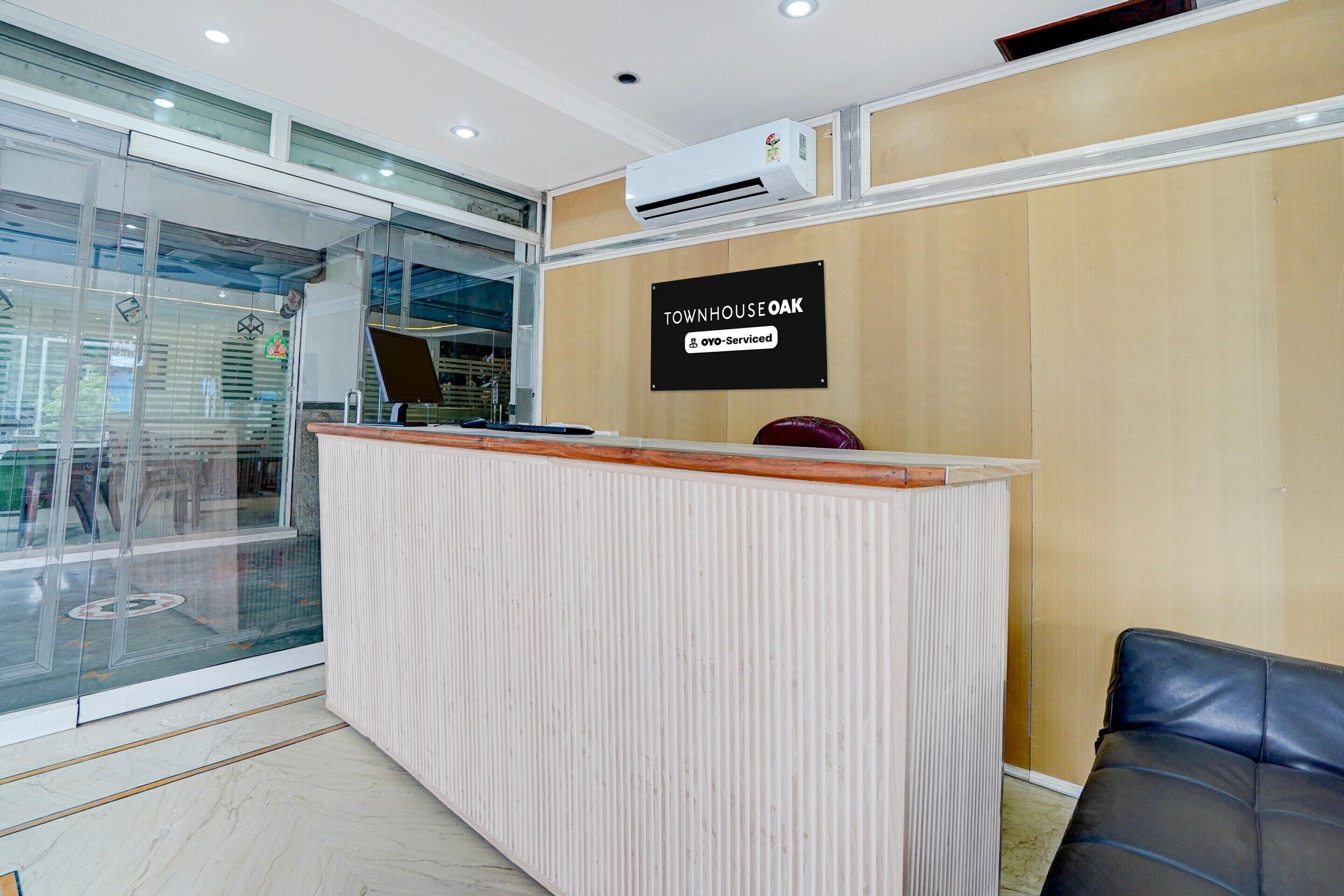 A reception desk with a sign that reads 'TOWNHOUSE OAK' and 'oyo-Serviced'.