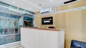A reception desk with a sign that reads 'TOWNHOUSE OAK' and 'oyo-Serviced'. - Super Deluxe Room Mauji's (Prayagraj)
