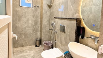 Un baño moderno con un espejo grande, un inodoro y un lavamanos.