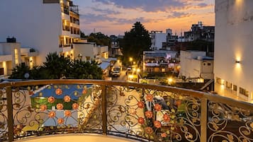 A balcony with a view of a cityscape at dusk, featuring a building labeled 'Grace Children's Academy.'
