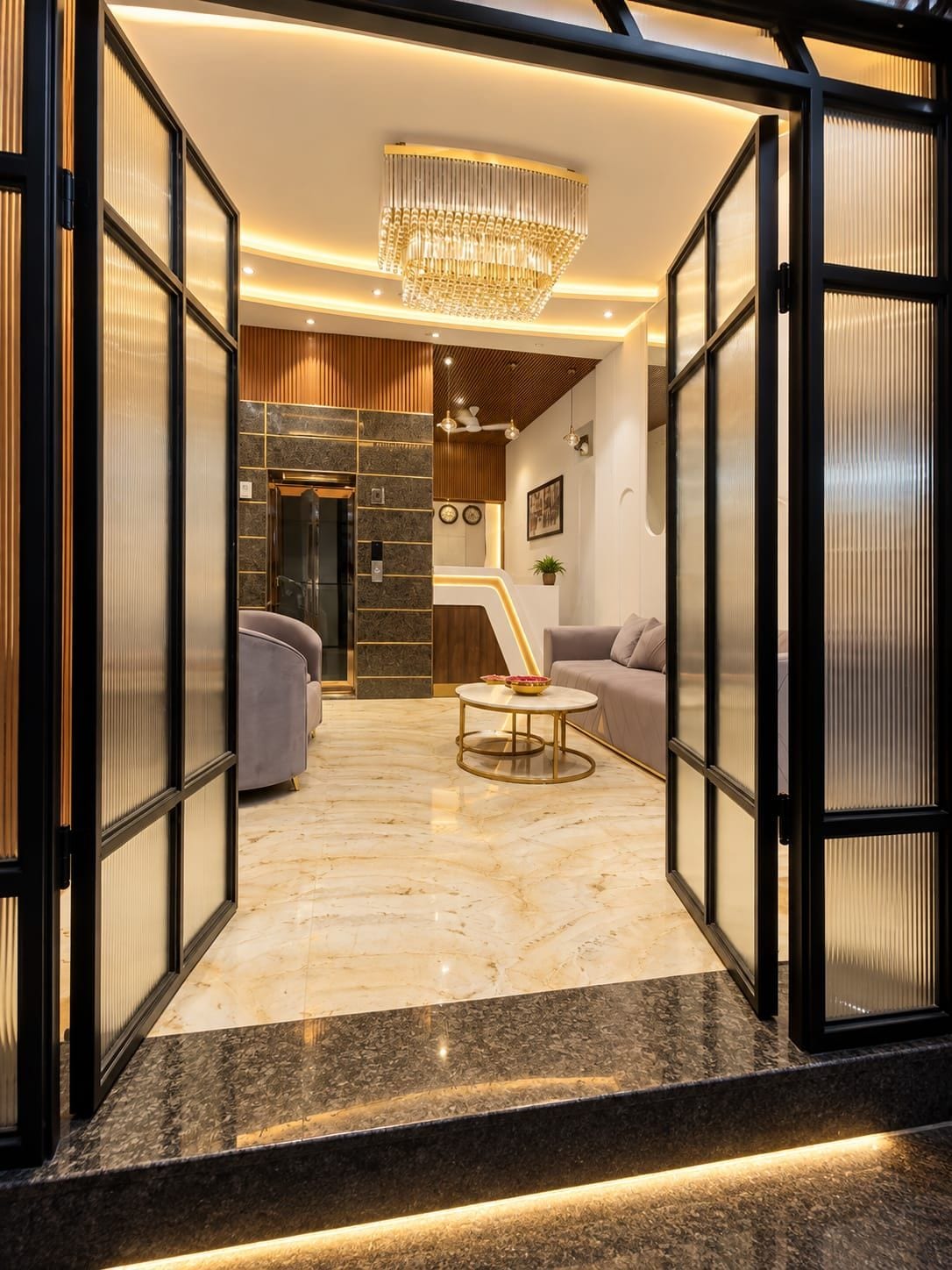 A modern lobby with a marble floor, a chandelier, and a reception desk.