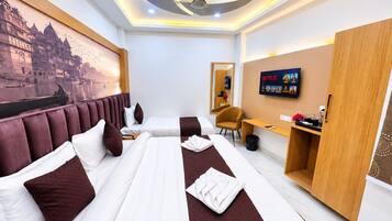 A hotel room with a large bed, a desk, a chair, a television, and a wall-mounted artwork.