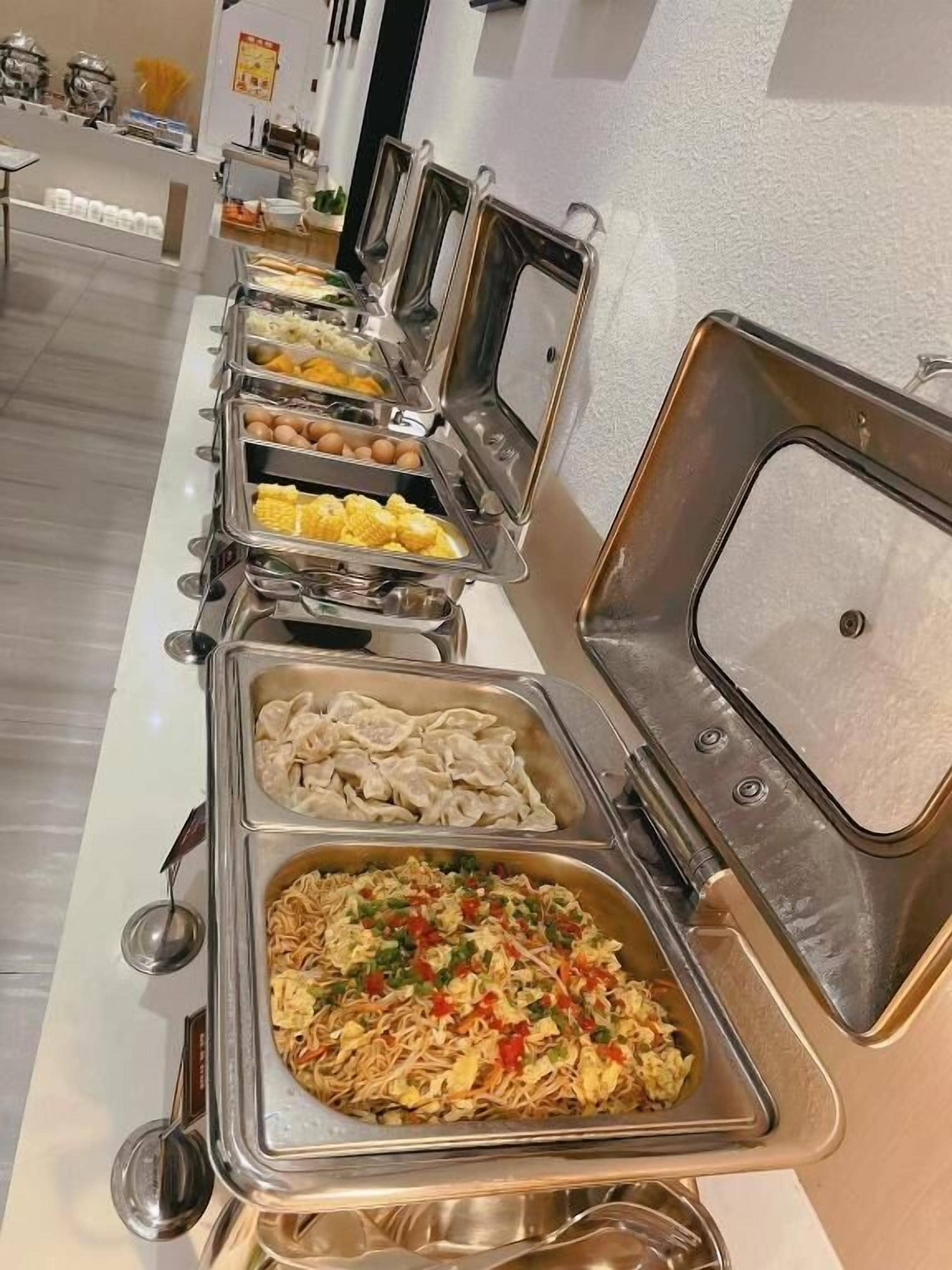 A buffet line with various food options.