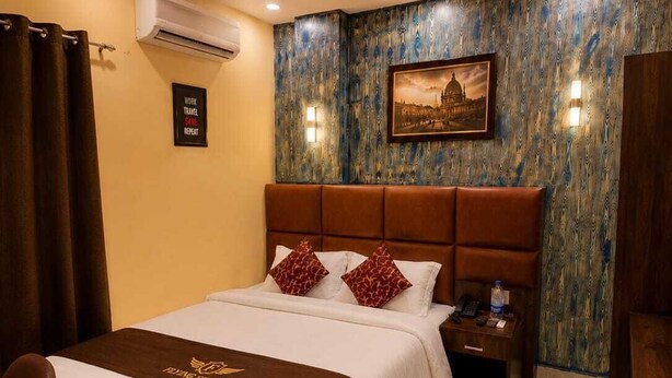 Habitación de hotel con una cama, una mesita de noche, un escritorio y aire acondicionado instalado en la pared.