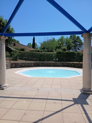 A swimming pool with a pergola overhead, surrounded by a stone wall and greenery. - A quiet villa overlooking the Gulf of Terre Blanche in the town of Tourrettes. (Tourrettes)