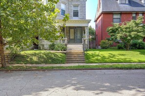 A two-story house with a stone facade, a front porch, and a well-maintained lawn.