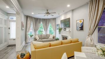 A living room with a sofa, a coffee table, and a fireplace.
