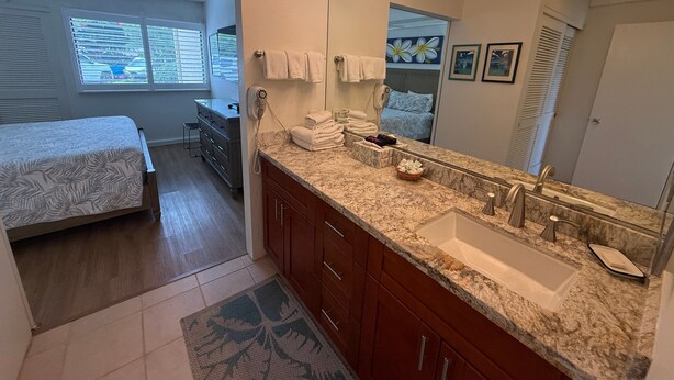 A modern bathroom with a large mirror, vanity, and a sink. - Ocean Views, Steps to Turtle Snorkeling at Honokeana Cove -Napili Point B24 (Lahaina)