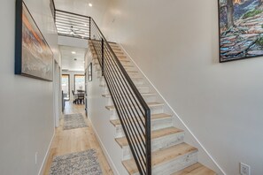 A staircase with a modern design, leading to a second-floor landing. - Game Room & Stunning Mtn Views! Cedar City Home (Cedar City)