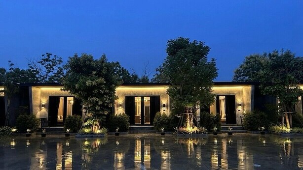 A modern building with a reflective water feature in front, surrounded by trees. - Siri Water Park & Resort (Lamphun)