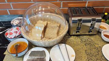 A kitchen counter with a toaster, a basket of bread, and various condiments.