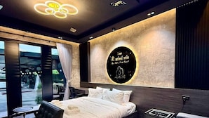 Quarto moderno com uma cama grande, um sofá, uma escrivaninha e vista para o exterior.
