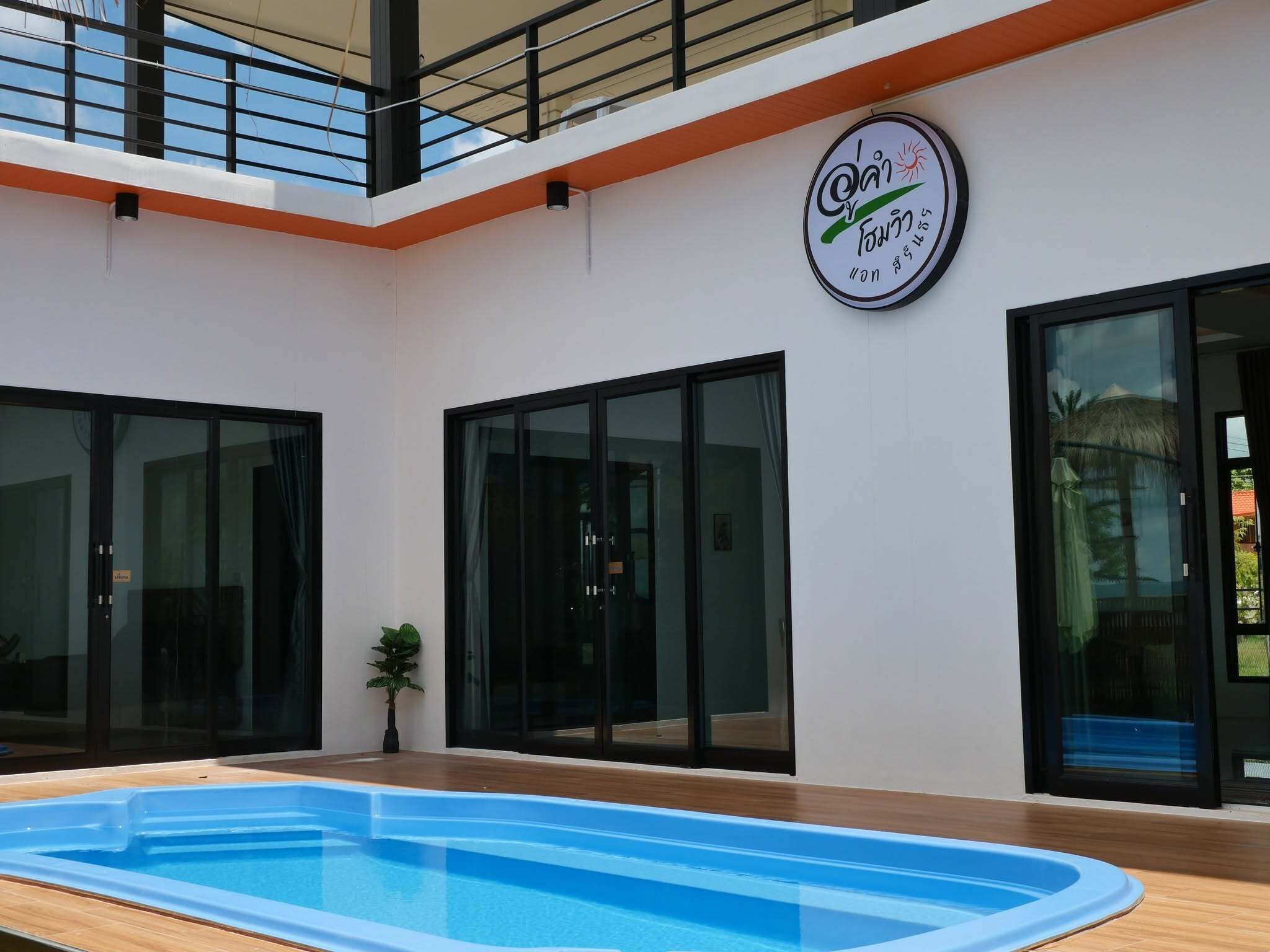 Una piscina interior moderna con puertas de cristal y un emblema de sol en la pared.