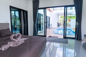 A modern bedroom with a large bed, a glass door leading to a balcony with a pool. - U-Kham Home View At Sirindhorn (Sirindhorn District)