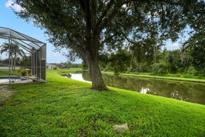 A transparent structure with a grassy area and a pond.