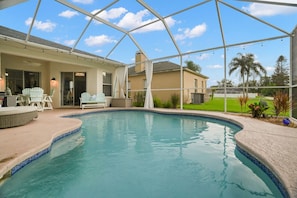 Ein Pool mit überdachter Terrasse, Sitzgelegenheiten im Freien und Blick auf die umliegende Landschaft.