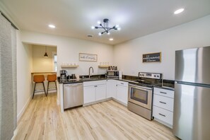 A modern kitchen with white cabinetry, stainless steel appliances, and a central island. - 7 Mi to Roaring River State Park! Gem w/ Fire Pit (Cassville)