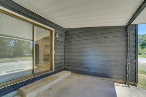 A covered porch with a concrete floor and a glass door leading to a room. - 7 Mi to Roaring River State Park! Gem w/ Fire Pit (Cassville)