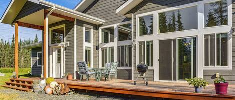 A modern house with a covered patio, large windows, and a deck.