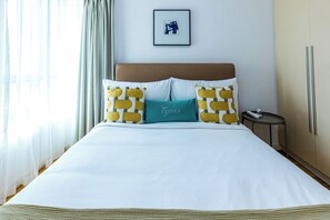 A hotel room with a bed, a nightstand, a lamp, and a framed picture on the wall. - Tyms 3BR 2BA Apt at Jing'an Maple Garden (Shanghai)