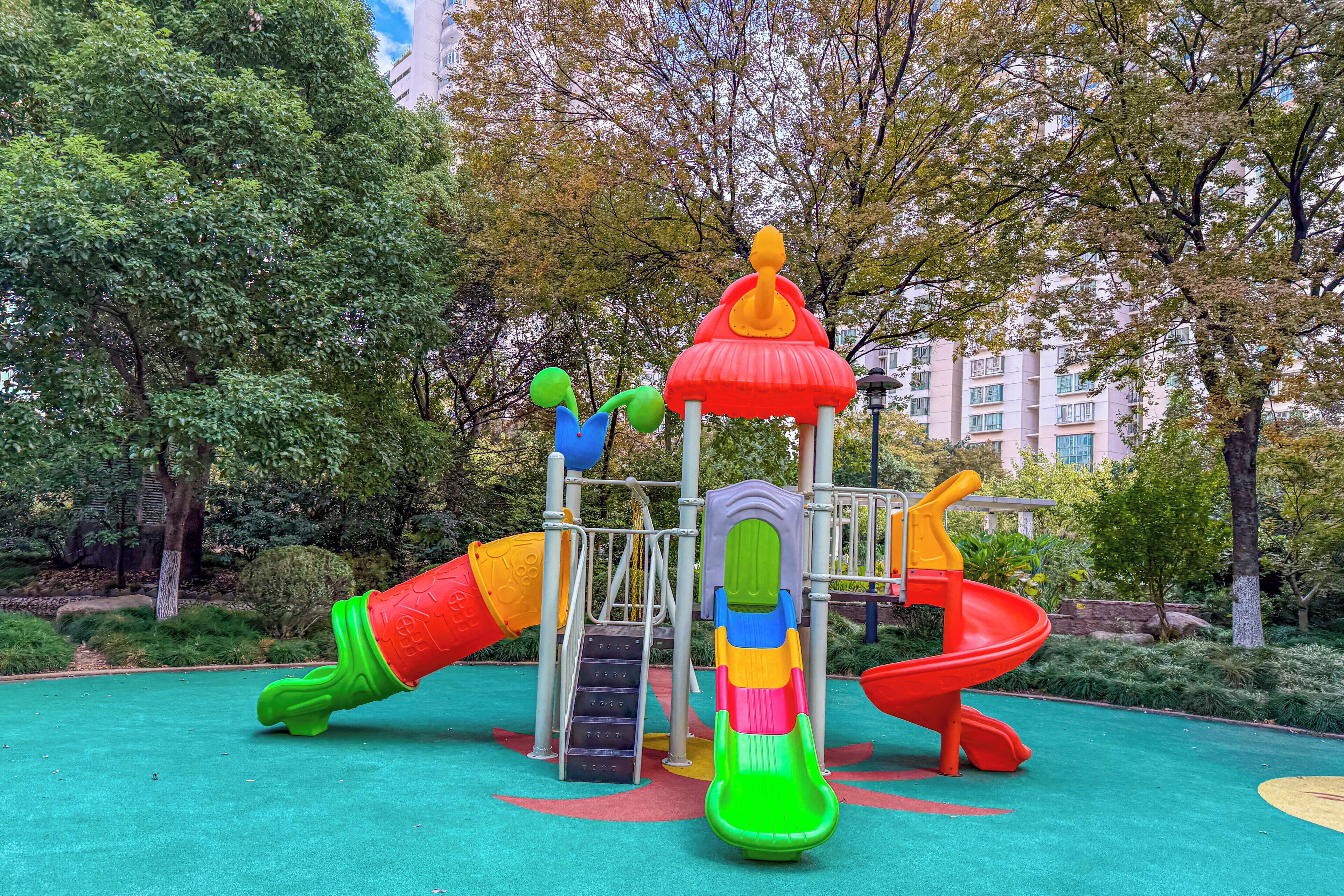 A playground with various play structures including slides and climbing elements.