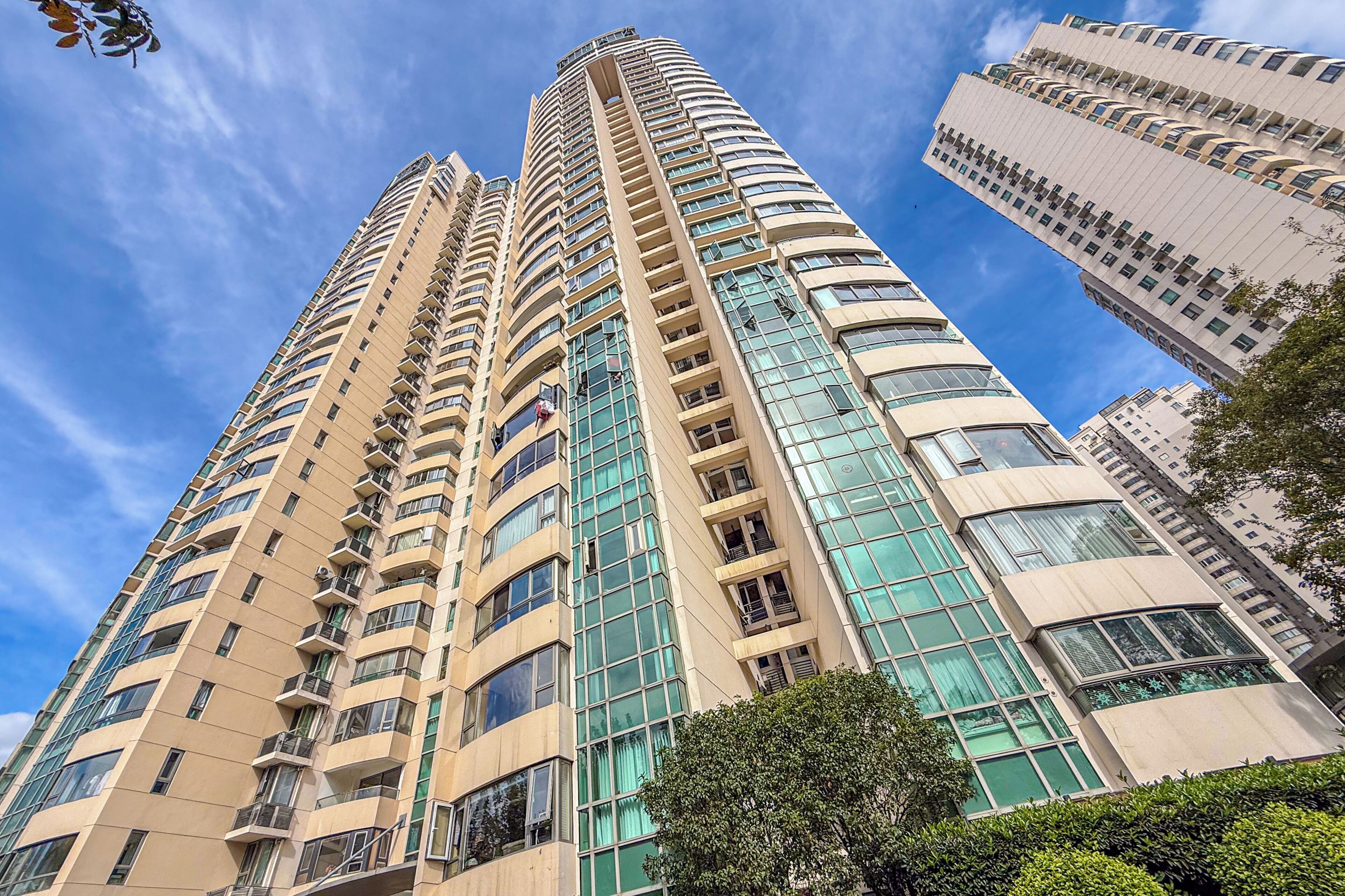 A high-rise building with multiple balconies and large windows.