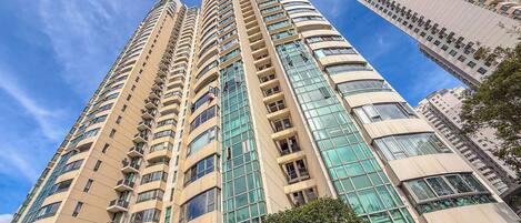A high-rise building with multiple balconies and large windows.