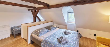 Une chambre à coucher avec un lit, un banc et une fenêtre.