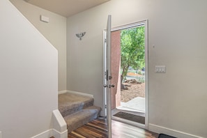 Un escalier menant à une porte donnant sur un espace extérieur aménagé.
