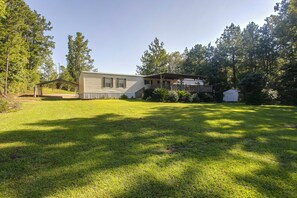 A single-story house with a covered porch and a fenced yard. - Waterfront Nature Escape on Altamaha River (Uvalda)