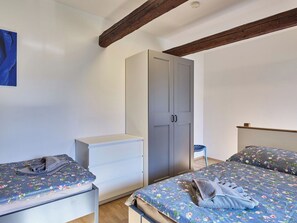 Ein Schlafzimmer mit zwei Betten, einem Kleiderschrank und einem kleinen Tisch.