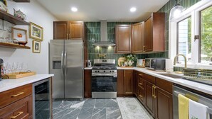 A kitchen with wooden cabinets, a stainless steel refrigerator, a stove, and a microwave. - Walk to Water, Dining! Modern City Point Haven (New Haven)