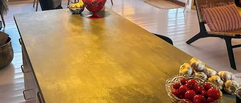 Een keuken met een groot kookeiland, een eethoek met stoelen en uitzicht op de omgeving.