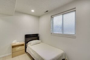 A small, single-bed room with a window and a bedside table. - Gateway to Mountain Fun! 5BR Utah Home (Lehi)