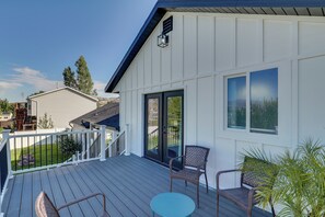 A residential deck with outdoor furniture, a sliding glass door, and a view of the neighborhood. - Gateway to Mountain Fun! 5BR Utah Home (Lehi)