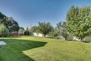 A well-maintained backyard with a lawn, a small shed, and a tree. - Gateway to Mountain Fun! 5BR Utah Home (Lehi)