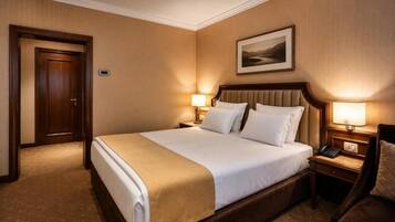 Een hotelkamer met een groot bed, twee nachtkastjes met lampen, een deur en een lijst met een afbeelding aan de muur.