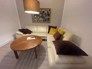 Ein Wohnzimmer mit einer Couch, einem Couchtisch und einem Gemälde an der Wand.