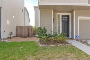 A residential building with a front yard, a wooden fence, and a door with a window. - Modern Efficiency Studio Near NRG & Medical Center (Houston)