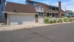 A residential street with houses featuring attached garages, brick chimneys, and a gravel driveway. - Normandy Beach! Phenomenal Ocean Block Location (Lavallette)