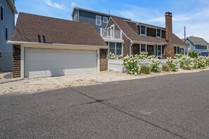 A residential street with houses featuring attached garages, brick chimneys, and a gravel driveway. - Normandy Beach! Phenomenal Ocean Block Location (Lavallette)