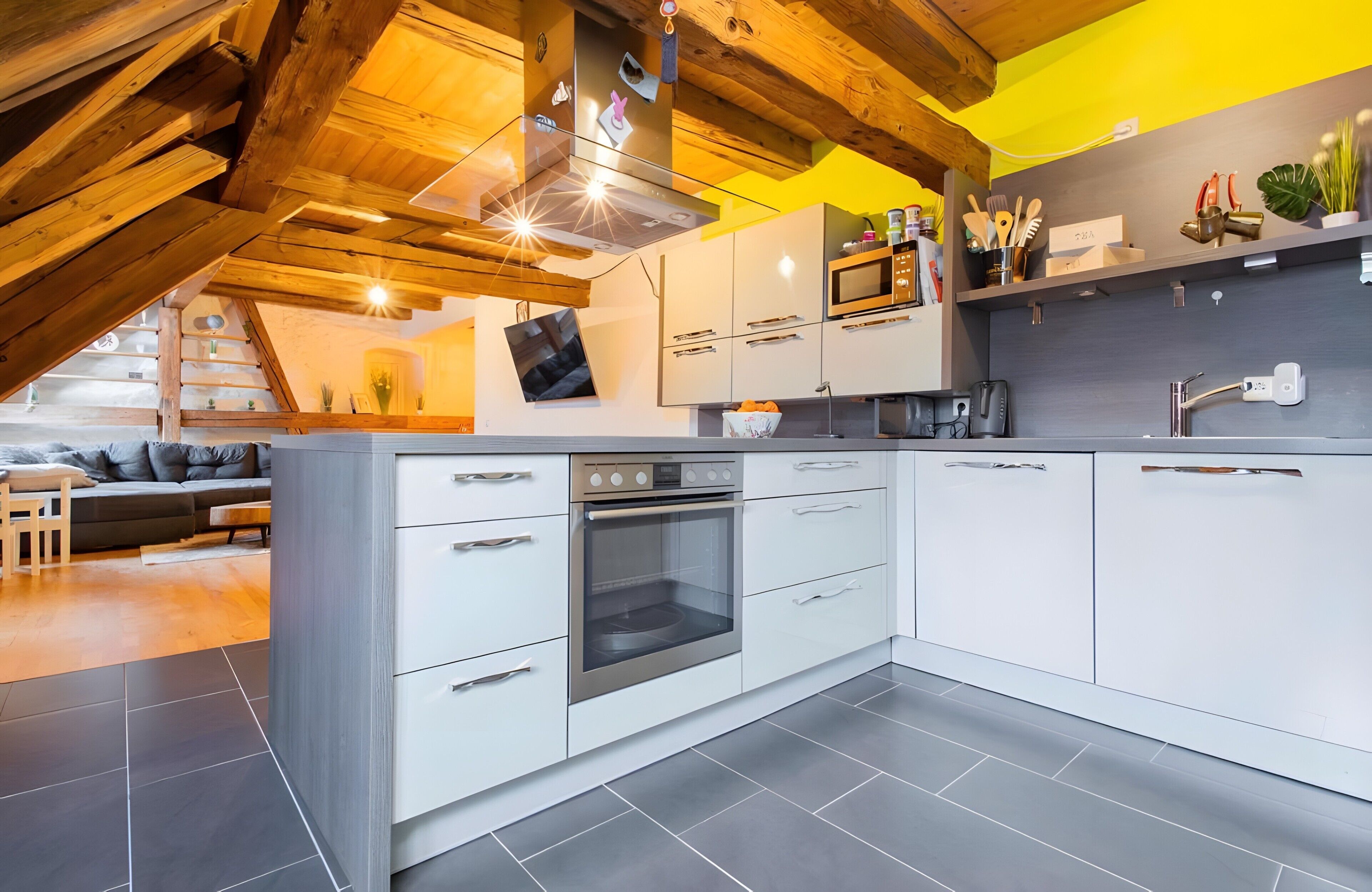 A modern kitchen with white cabinets, a built-in oven, and a microwave.