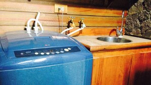 A blue water heater with a digital display, connected to a sink with a faucet.