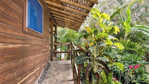 A wooden building with a stone pathway leading to a covered wooden structure.