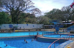 A swimming pool with multiple lanes, a diving platform, and a wall with a logo.