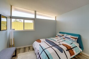 A bedroom with a bed, a window, a chair, and a wall-mounted shelf. - Mid-Century Modern Gem 3 Mi to F1 Action (Las Vegas)