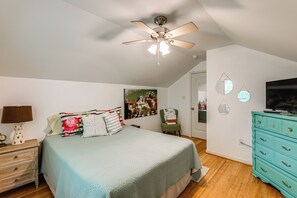 A bedroom with a bed, a ceiling fan, a dresser, a television, and a painting on the wall. - 3 Mi to Assateague Beach! Home w/ Furnished Deck (Chincoteague)
